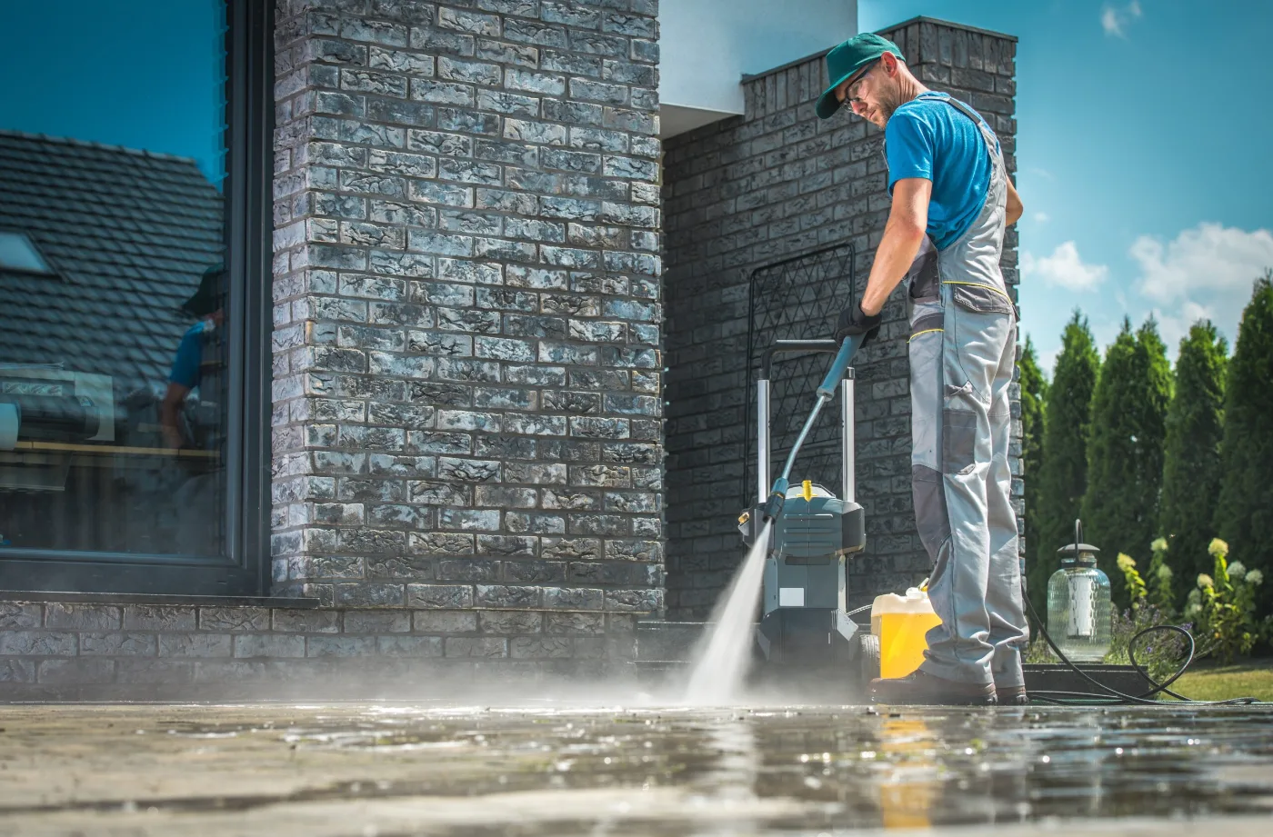 Operator pressure cleaning a paved commercial entrance