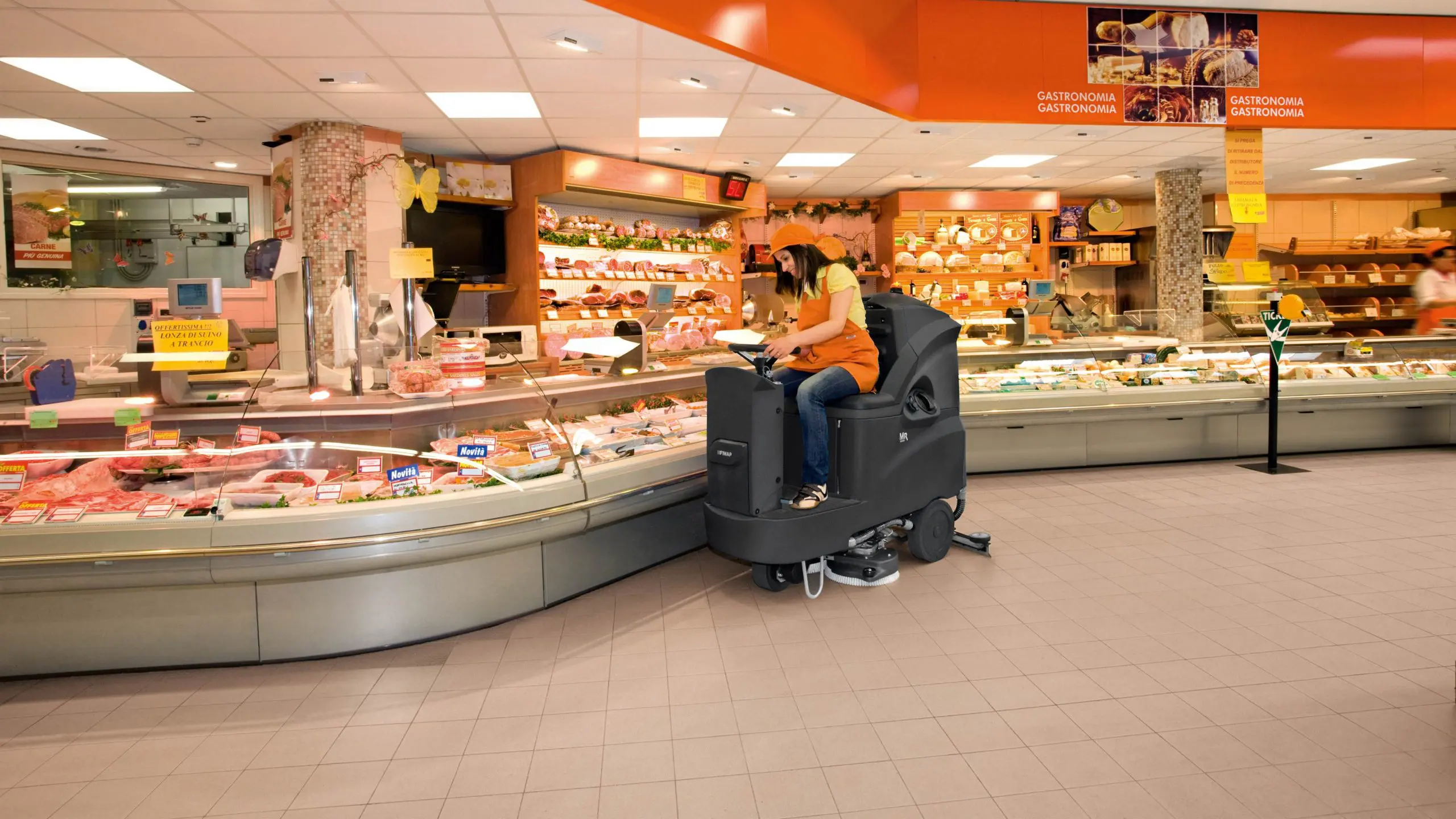 Ride-on floor scrubber cleaning a large sealed floor